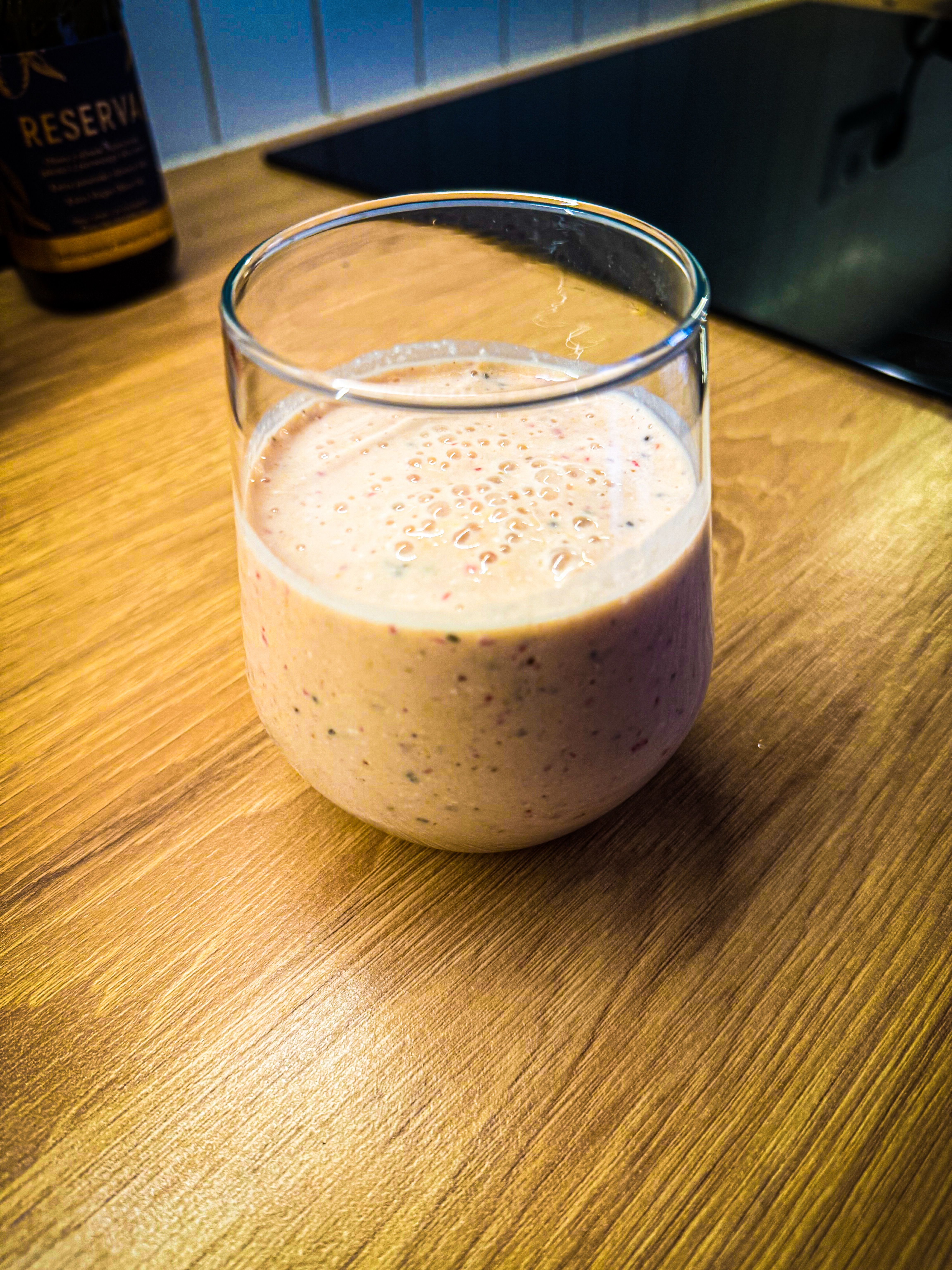 Breakfast smoothie in a glass on a wooden countertop