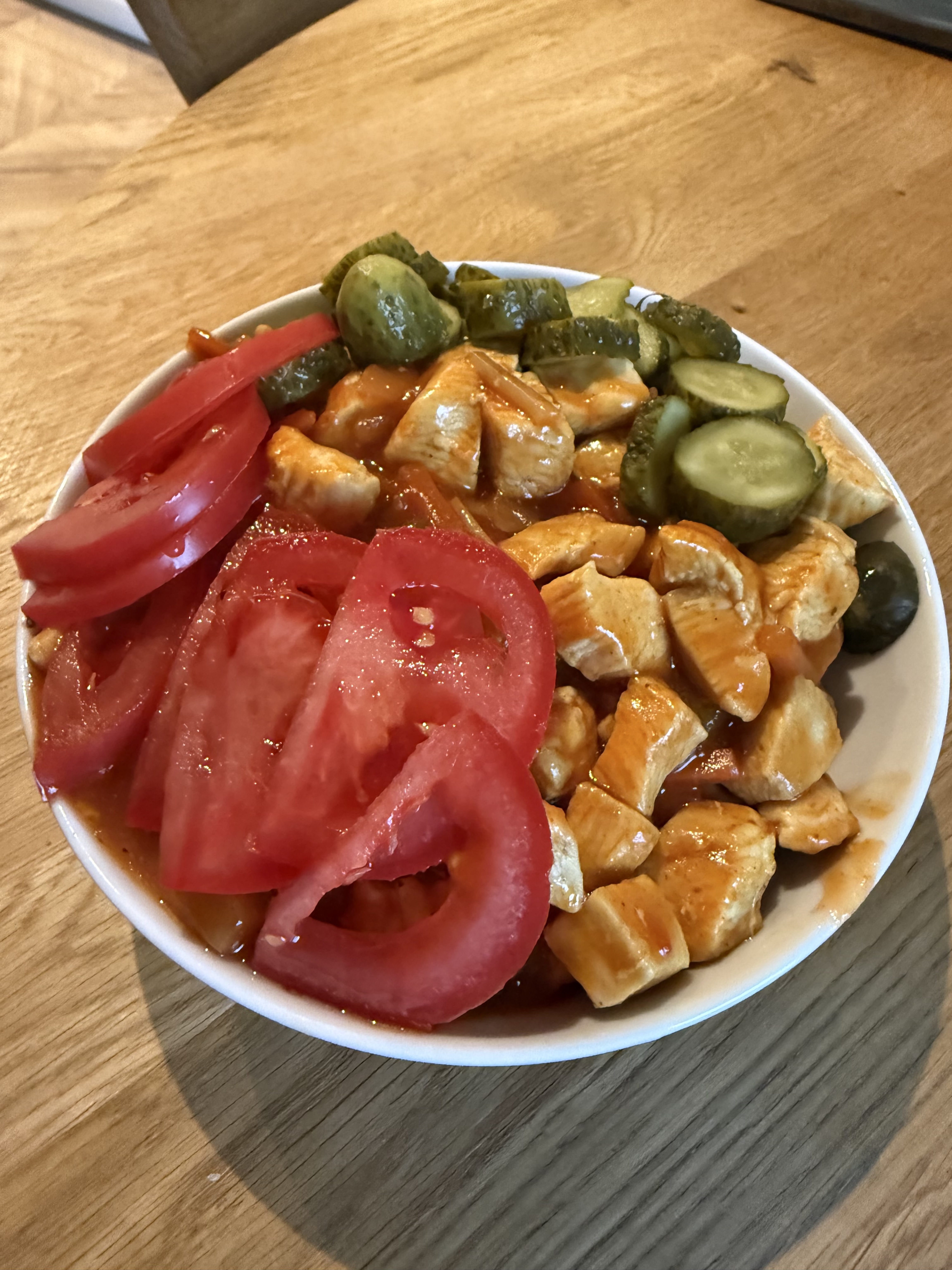 Lunch on 2026-07-21: couscous bowl with fried chicken in sweet-and-sour sauce, sliced cucumbers, and tomato