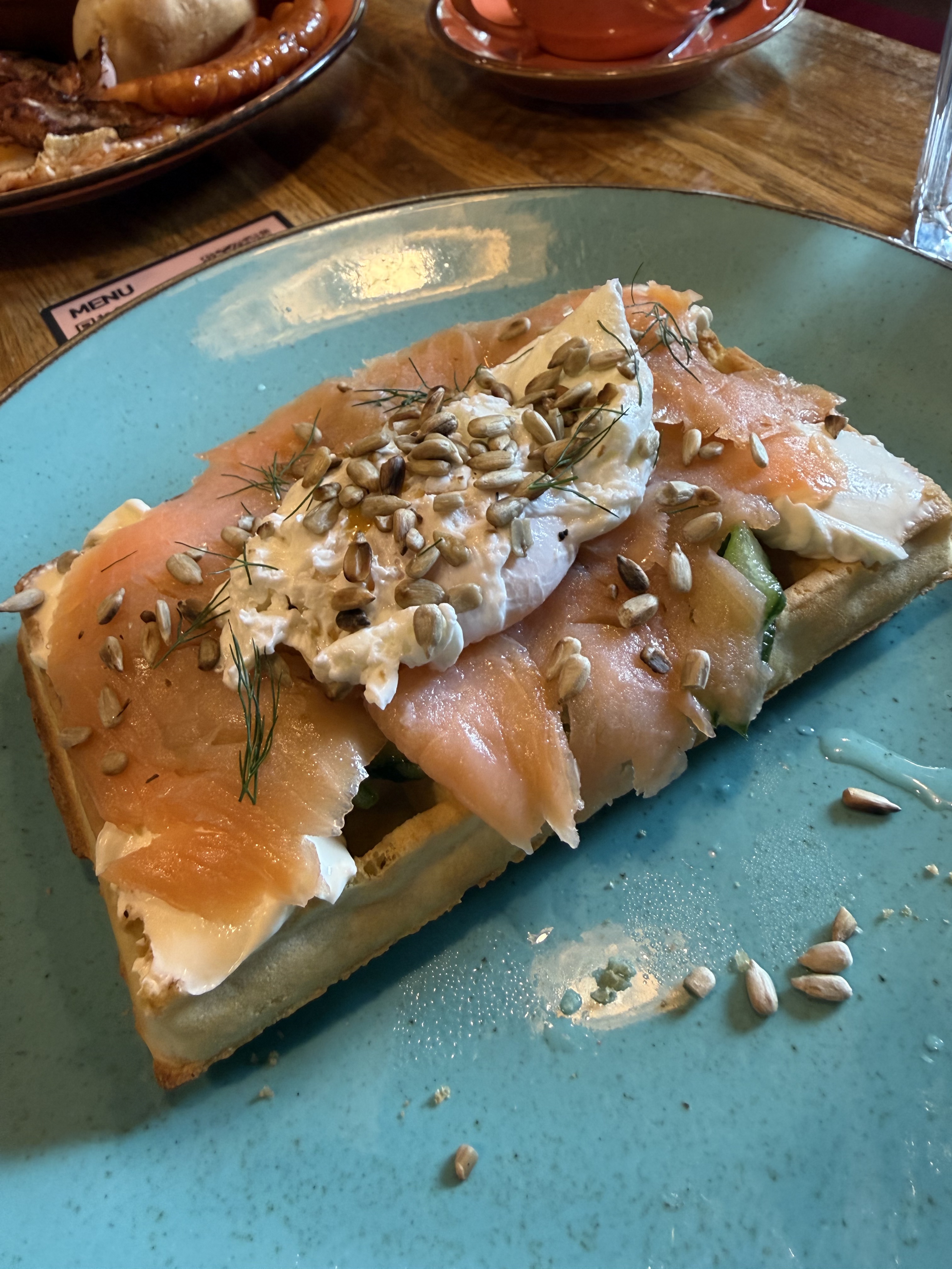 Breakfast on 2026-07-24: open toast with smoked salmon, a poached egg, creamy spread, cucumber, dill, and sunflower seeds